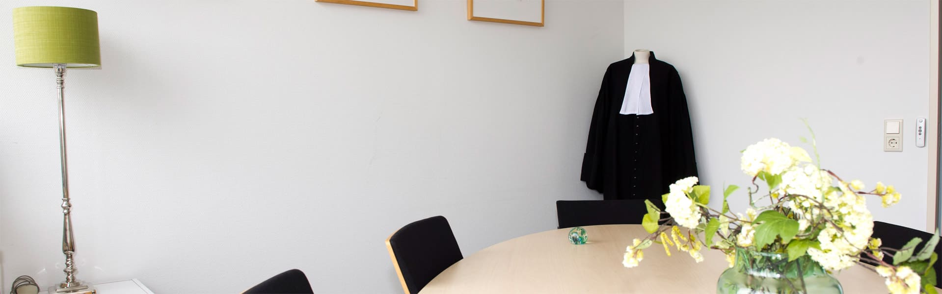 Vergaderkamer van het kantoor met een advocatentoga aan de wand